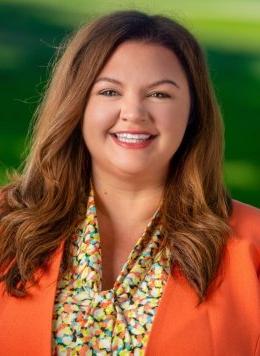 Portrait of Melanie Lacy Sorenson wearing an orange jacket and multicolored blouse